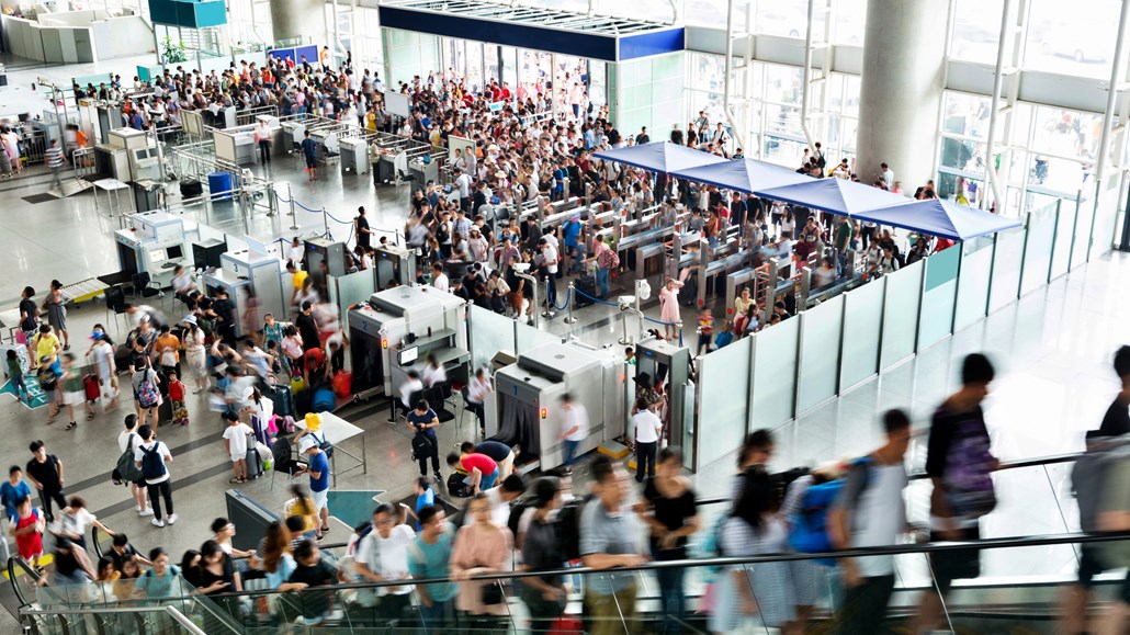 人们在拥挤的机场通过安检