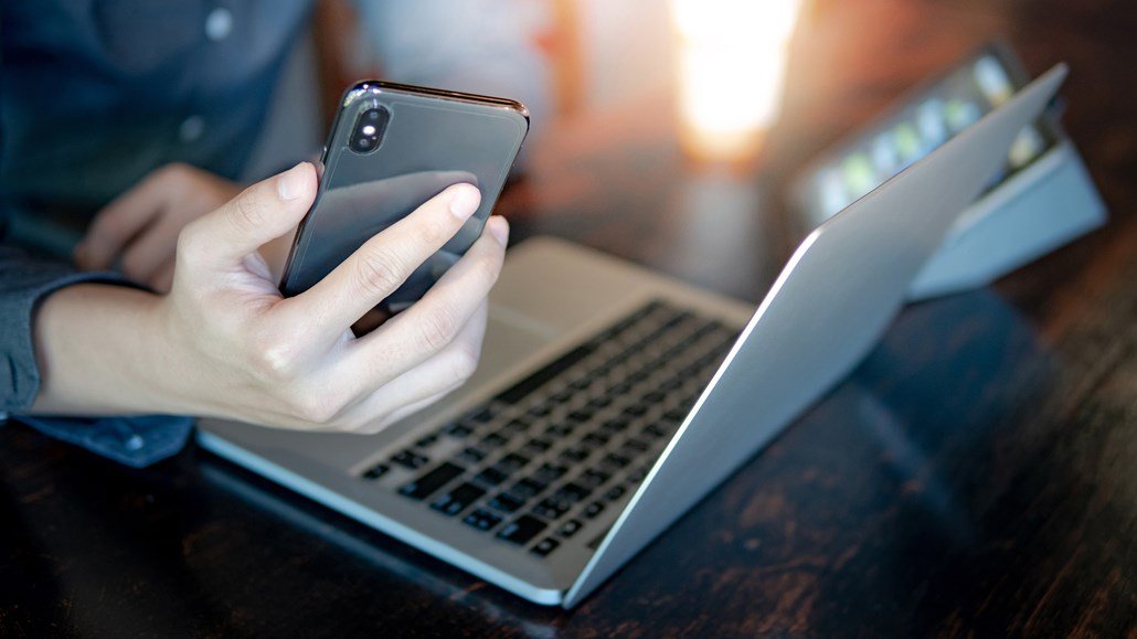 man with phone and laptop