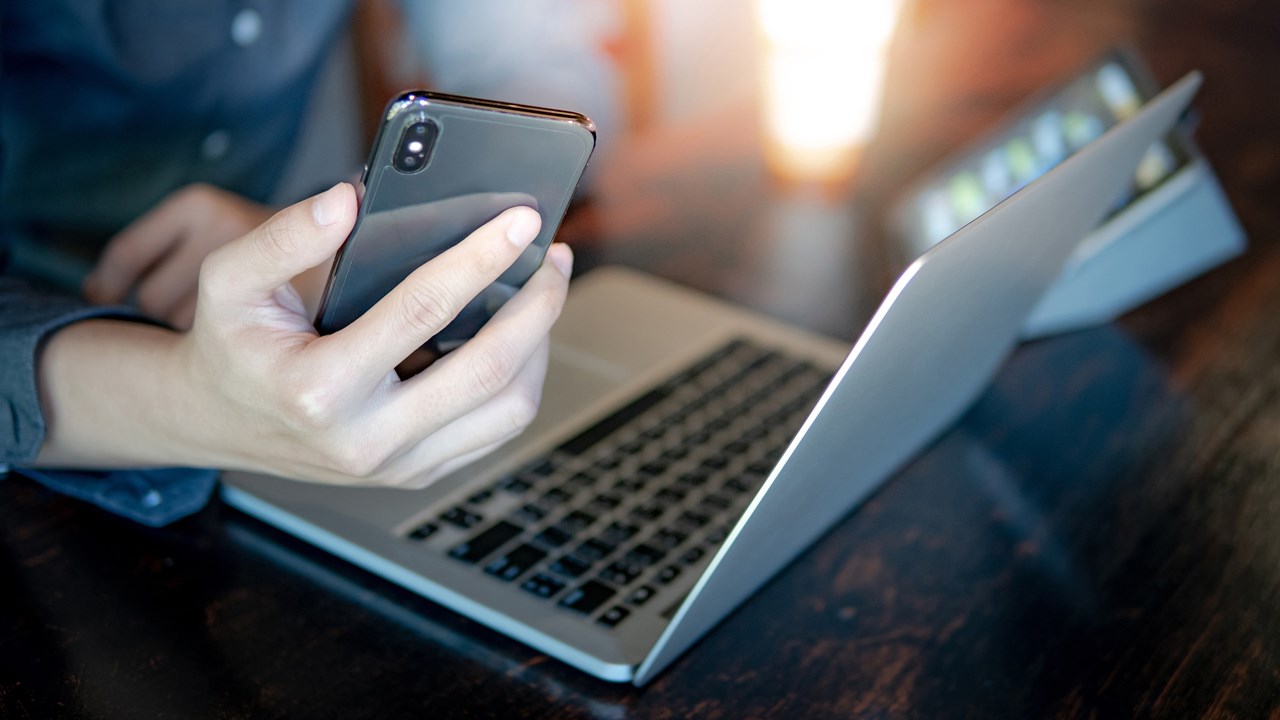 man with phone and laptop